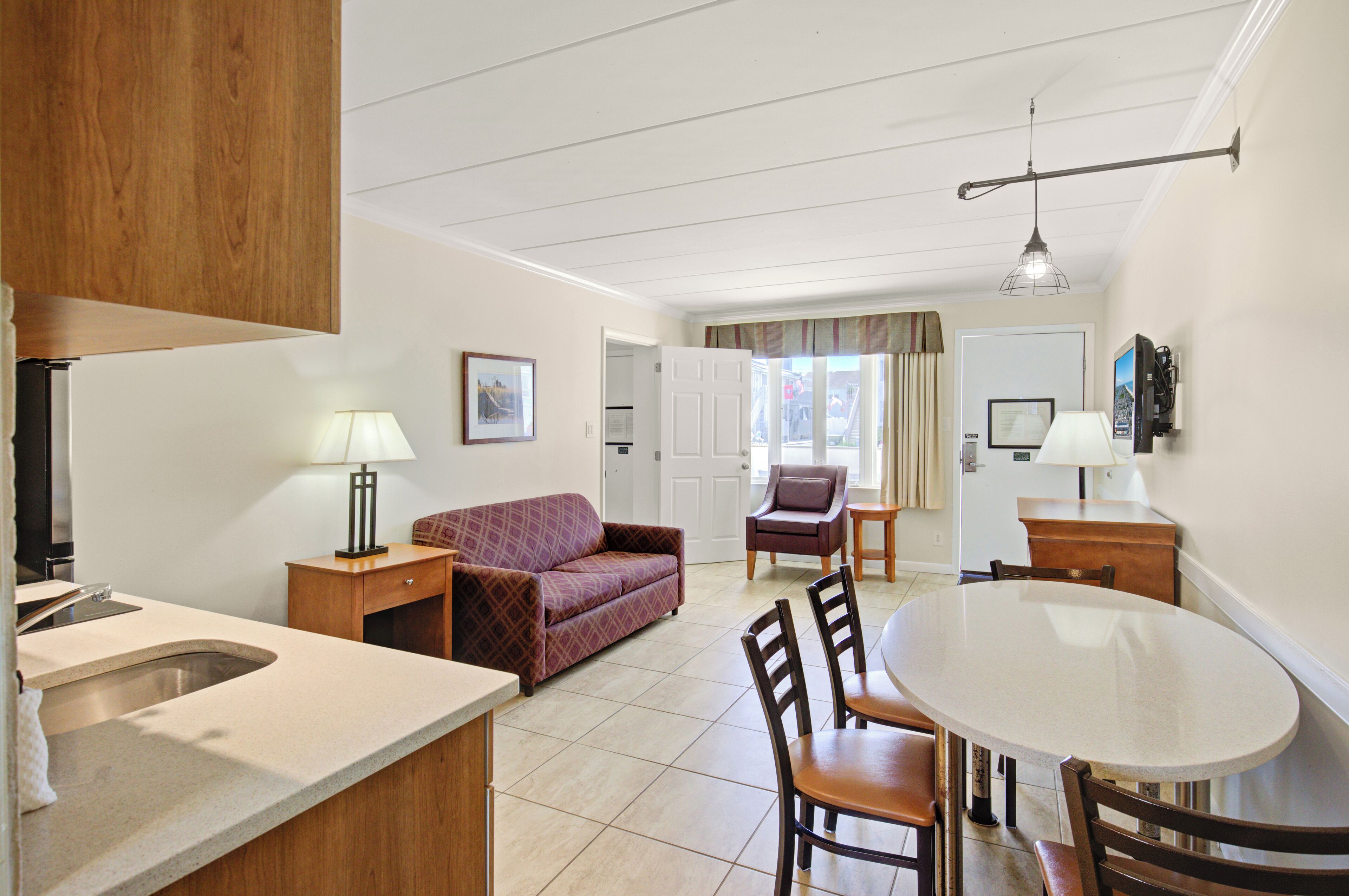 A compact living space with a kitchenette, a dining area, and a sofa.