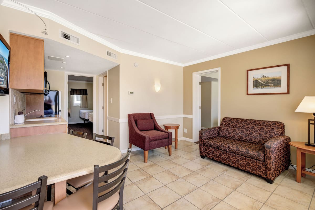 A dining area with a table and chairs, a sofa, and a small side table.