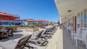 Ein Hotel direkt am Strand mit Liegestühlen, Außenbereich und roten Sonnenschirmen.