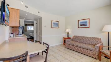 A compact living space with a kitchenette, a dining area, and a sofa.