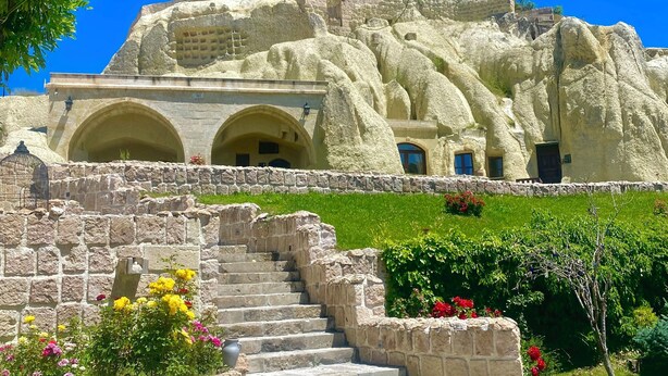 A historic building with stone arches and a staircase leading to a door. - Seraphim Cave Suites & Spa (Ürgüp)