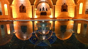 A reflective pool with geometric patterns, arched brick walls, and statues. - Seraphim Cave Suites & Spa (Ürgüp)