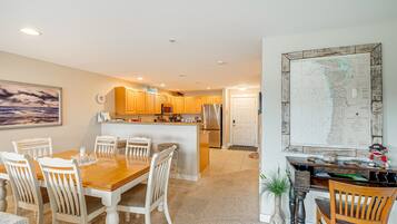 A spacious kitchen with wooden cabinets, a central island, and a dining area with a wooden table and chairs.