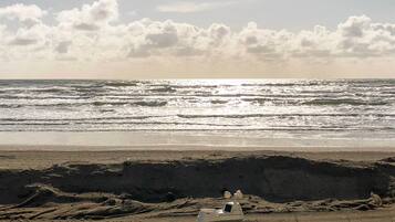 A beach with waves and a clear sky.