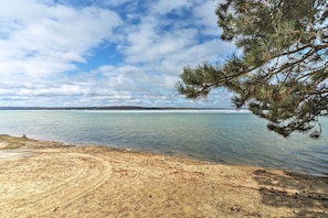 A beach with clear water and a distant shoreline.