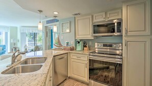 A modern kitchen with granite countertops, stainless steel appliances, and light-colored cabinetry. - Lagoon & Fountain Views: Villa in Palmetto Dunes (Hilton Head)