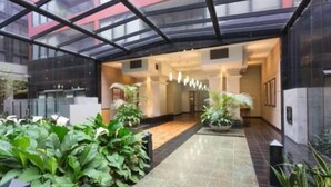 A modern hotel lobby with a glass ceiling, potted plants, and a tiled floor. - Penthouse Apartment in Melb CBD Perfect Location (Melbourne)