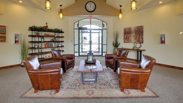 A lobby with leather chairs, a coffee table, a bookshelf, and a clock on the wall. - 360 Mtn Views & Shared Hot Tub: Cozy Frisco Condo! (Frisco)