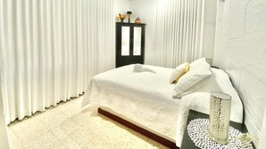 A bedroom with a bed, white curtains, a ceiling fan, a bedside table with a lamp, and a nightstand. - LOVELY VILLA IN PLAYACAR PHASE 1,  PRIVATE POOL (playa del carmen)