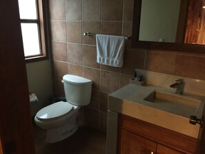 Ein kleines Badezimmer mit Toilette, Waschbecken und Spiegel.