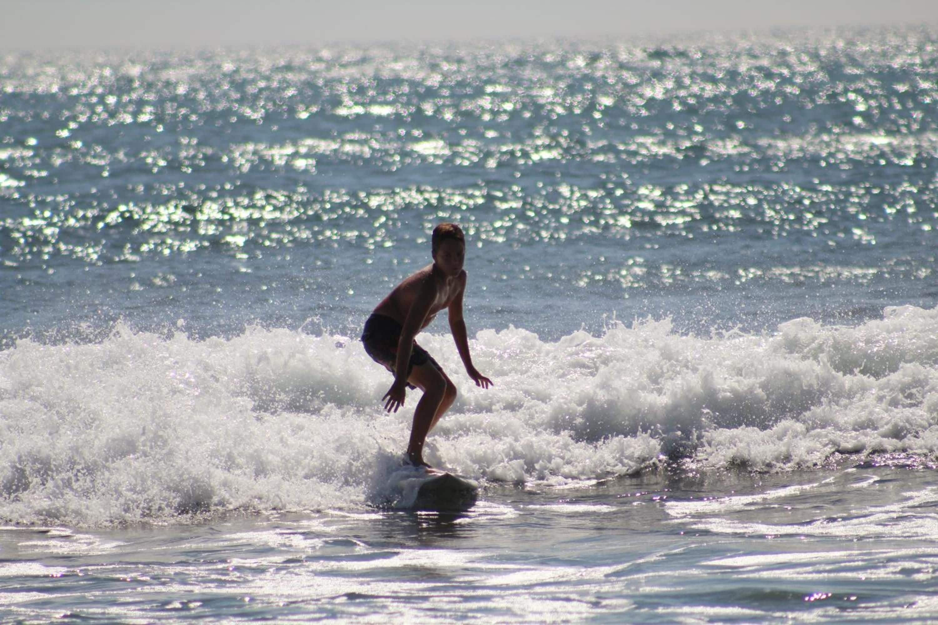 A person surfing on a wave in the ocean.