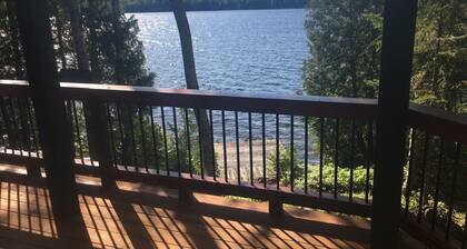 Häuschen am Wasser auf unberührtem Gras und Loon Lake