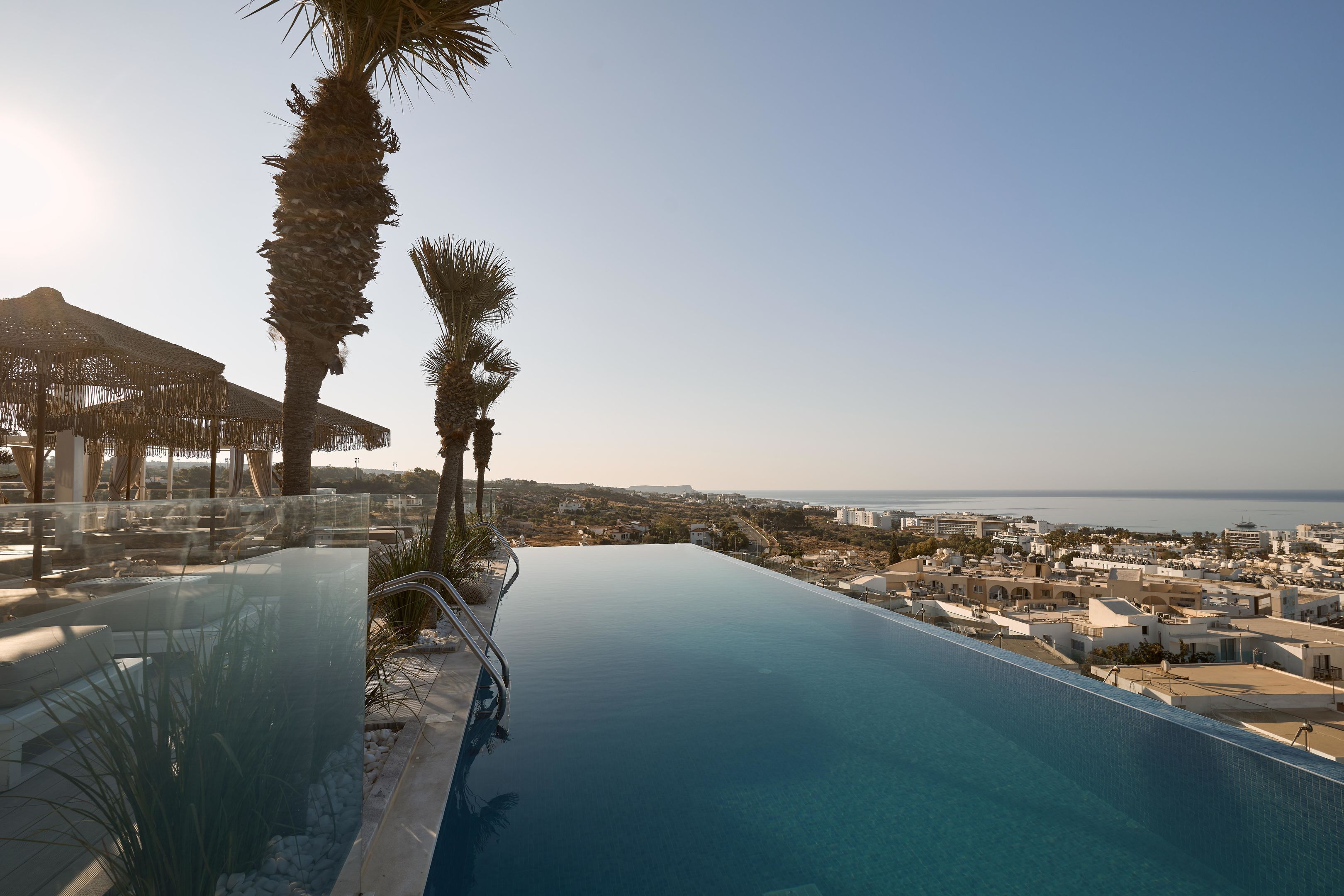 Una piscina a sfioro con vista chiara sul mare e sugli edifici sullo sfondo.