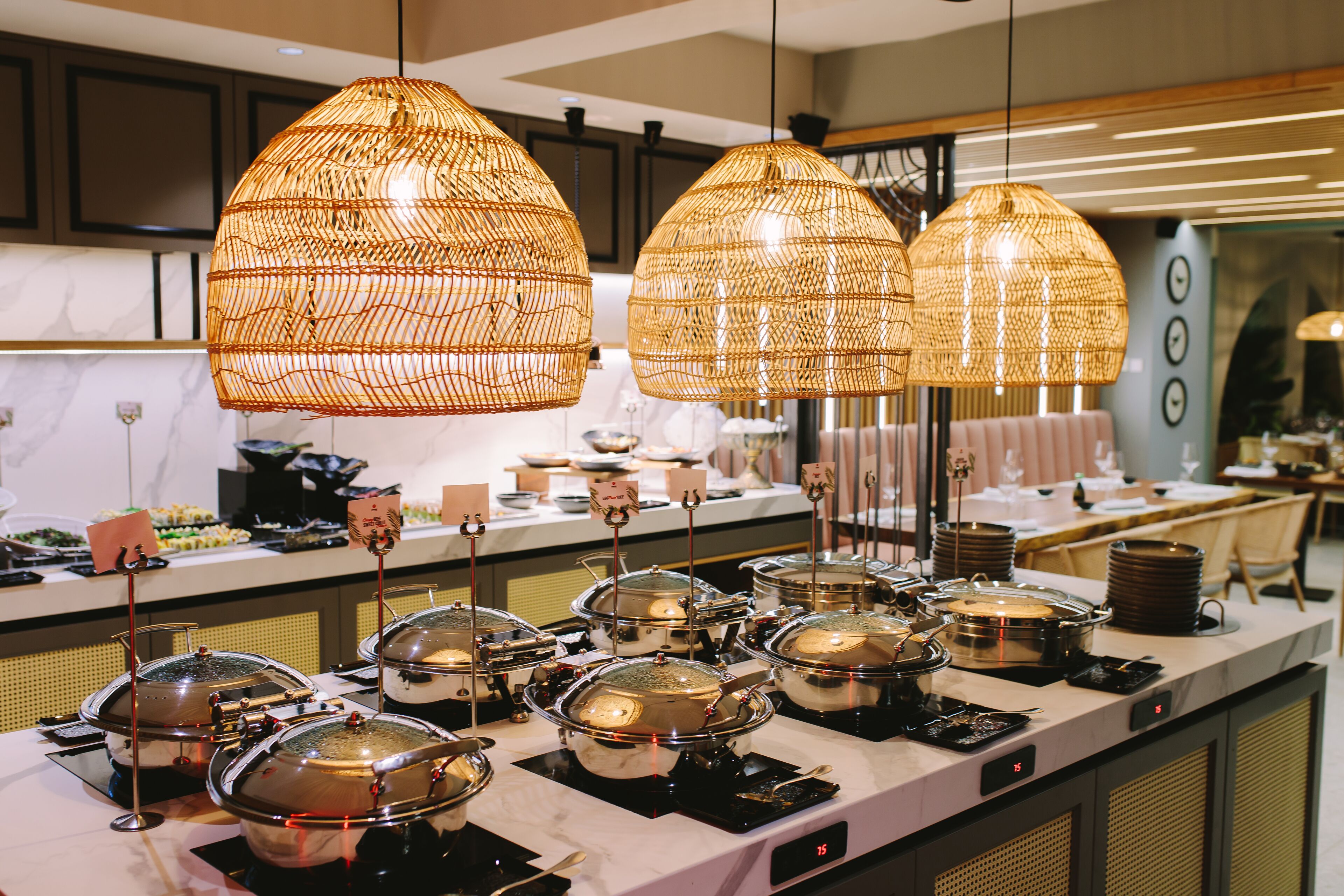 Ein reichhaltiges Buffet mit mehreren Speiseauslagen und hängenden Korbschwingen als Lampen.