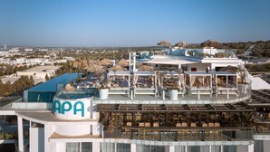 A rooftop terrace with outdoor seating, a pool, and a view of the city. - Hotel Napa Suites - Adults Only (Ayia Napa)