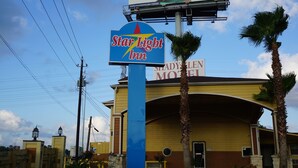A hotel with a prominent Star Light Inn sign, a large building with a yellow facade, and a sign for the Shady Feet Motel. - Star Light Inn (Channelview)