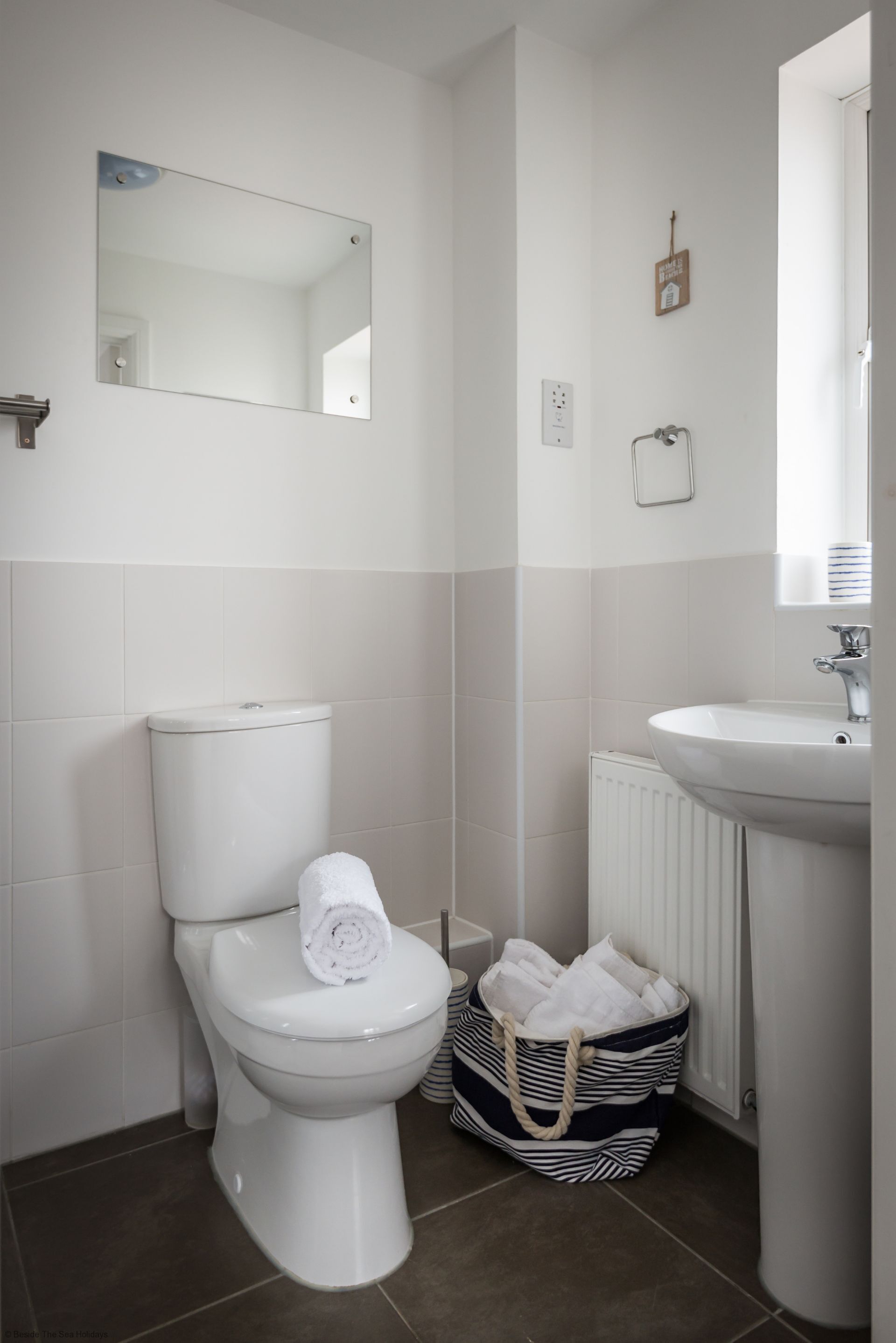 Un bagno moderno con il water, un lavandino e uno specchio.