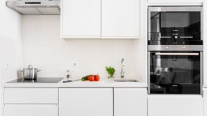 A modern kitchen with white cabinetry, a Siemens oven, and a stainless steel range hood. - Chiado | SPACIOUS & PEACEFUL | Family-Friendly (Lisboa)