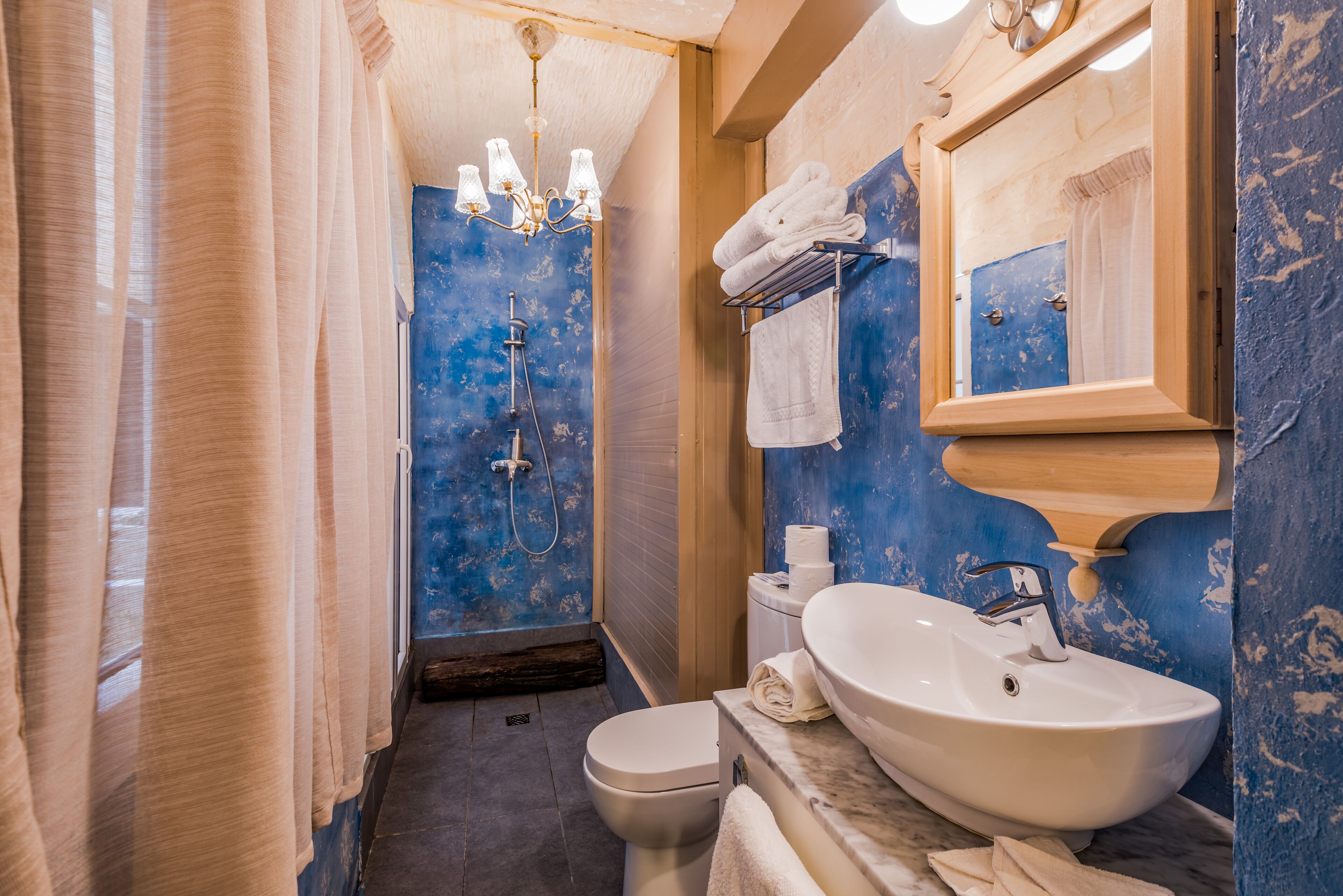 Une salle de bain équipée d’une douche, de toilettes, d’un lavabo et d’un miroir.