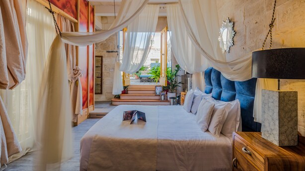 Un dormitorio con una cama grande, una mesita de noche de madera y vistas al exterior.