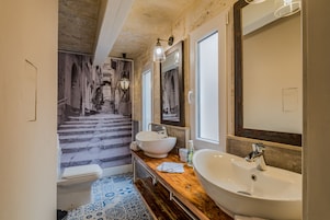 Un baño con un lavamanos grande, un espejo y una ventana.