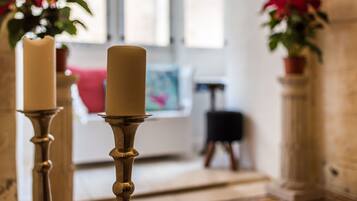 Portavelas con velas en una habitación con ventana y un cuadro en la pared.