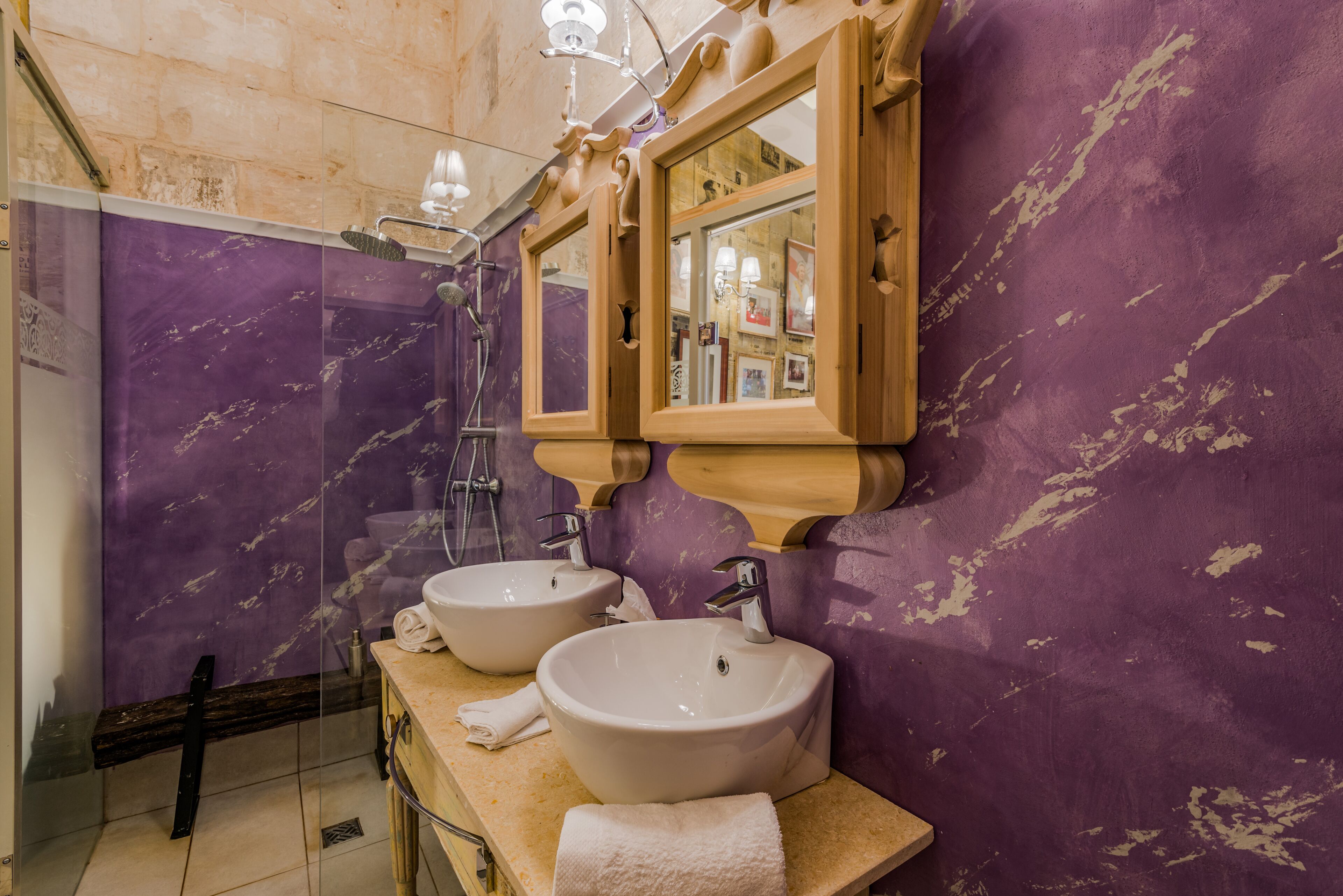 A bathroom with two sinks, a mirror, and a shower.