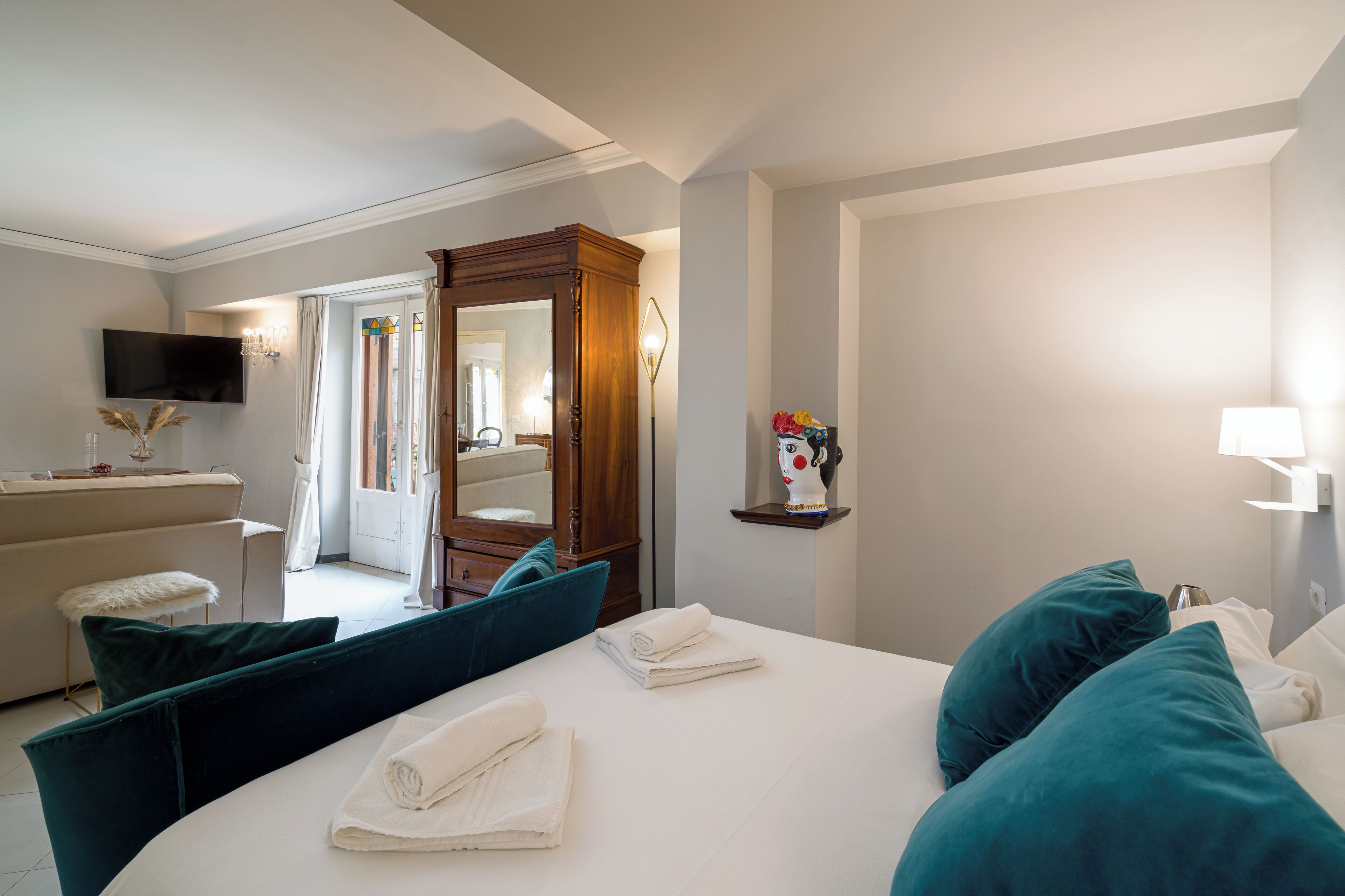 Una habitación de hotel con cama, escritorio, televisor y baño.