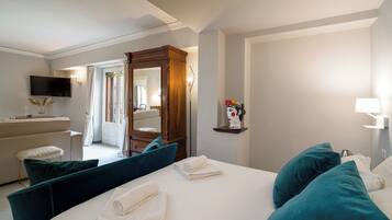Una habitación de hotel con cama, escritorio, televisor y baño.