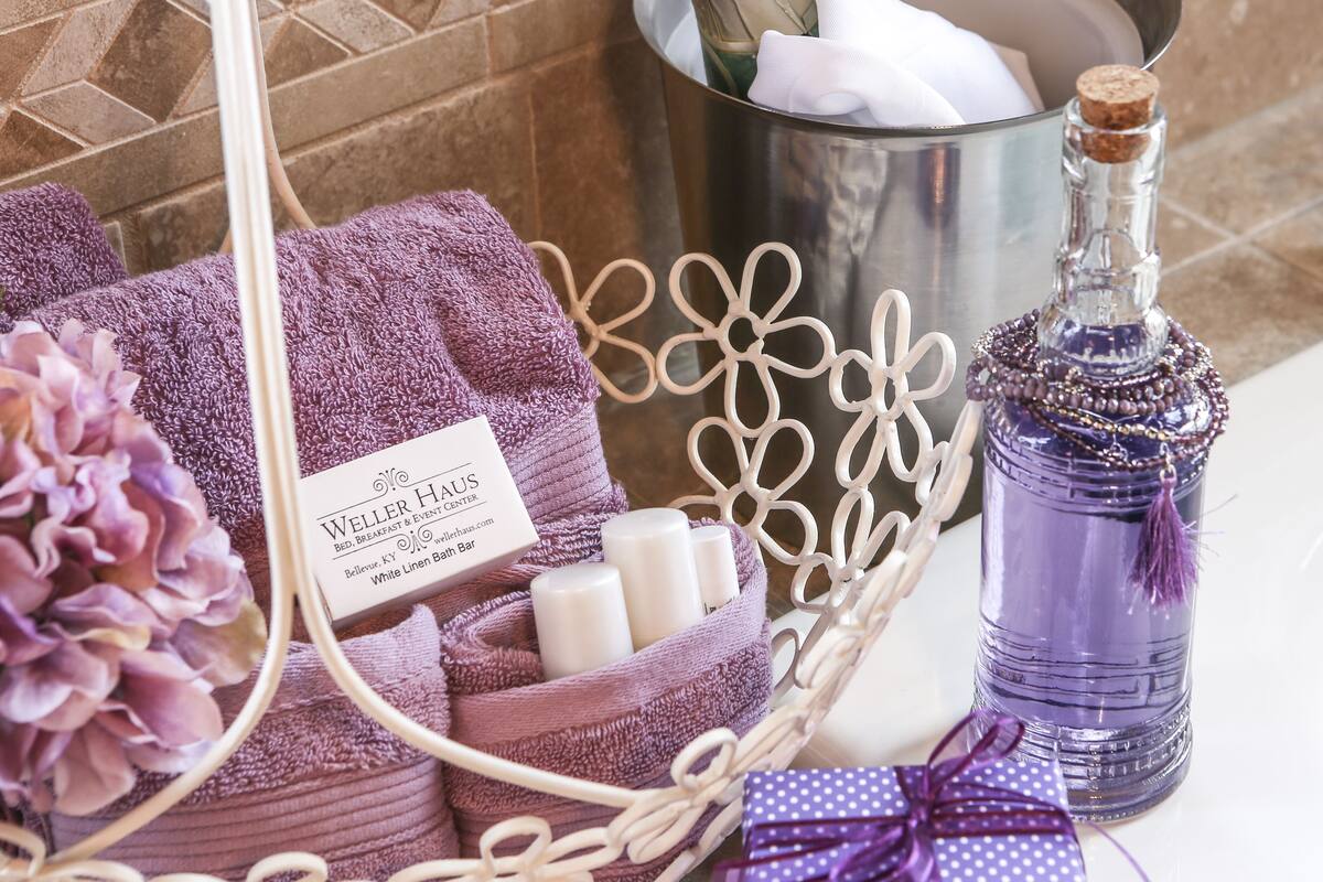 A bathroom setting with a purple towel, a bottle, and a tissue box labeled "Weller Haus".