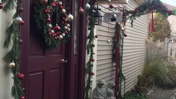 A house with a red door, decorated with Christmas ornaments and a wreath.