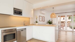 Een moderne keuken met inbouwapparatuur, een houten aanrechtblad en uitzicht op het buitenterras.