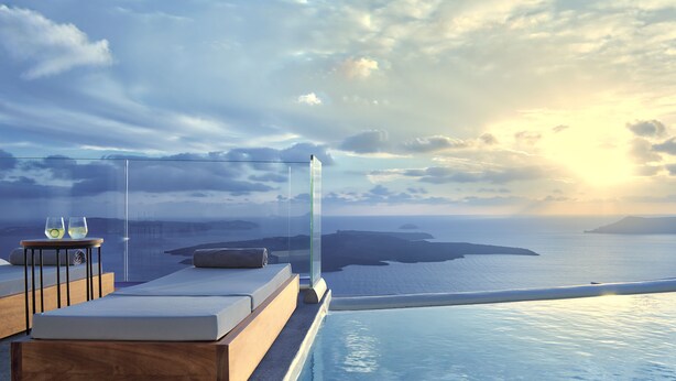 A modern infinity pool with a view of the sea and distant islands. There are lounge chairs and a small table with glasses. - Villa Ioli Anastasia (Santorini)