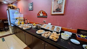 Un bufé de desayuno con diversas opciones de comida y una estación de café.