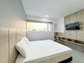 Escritorio, cortinas blackout y tabla de planchar con plancha 