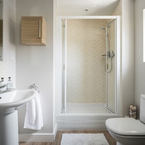 Une salle de bain avec une douche, un lavabo et des toilettes.