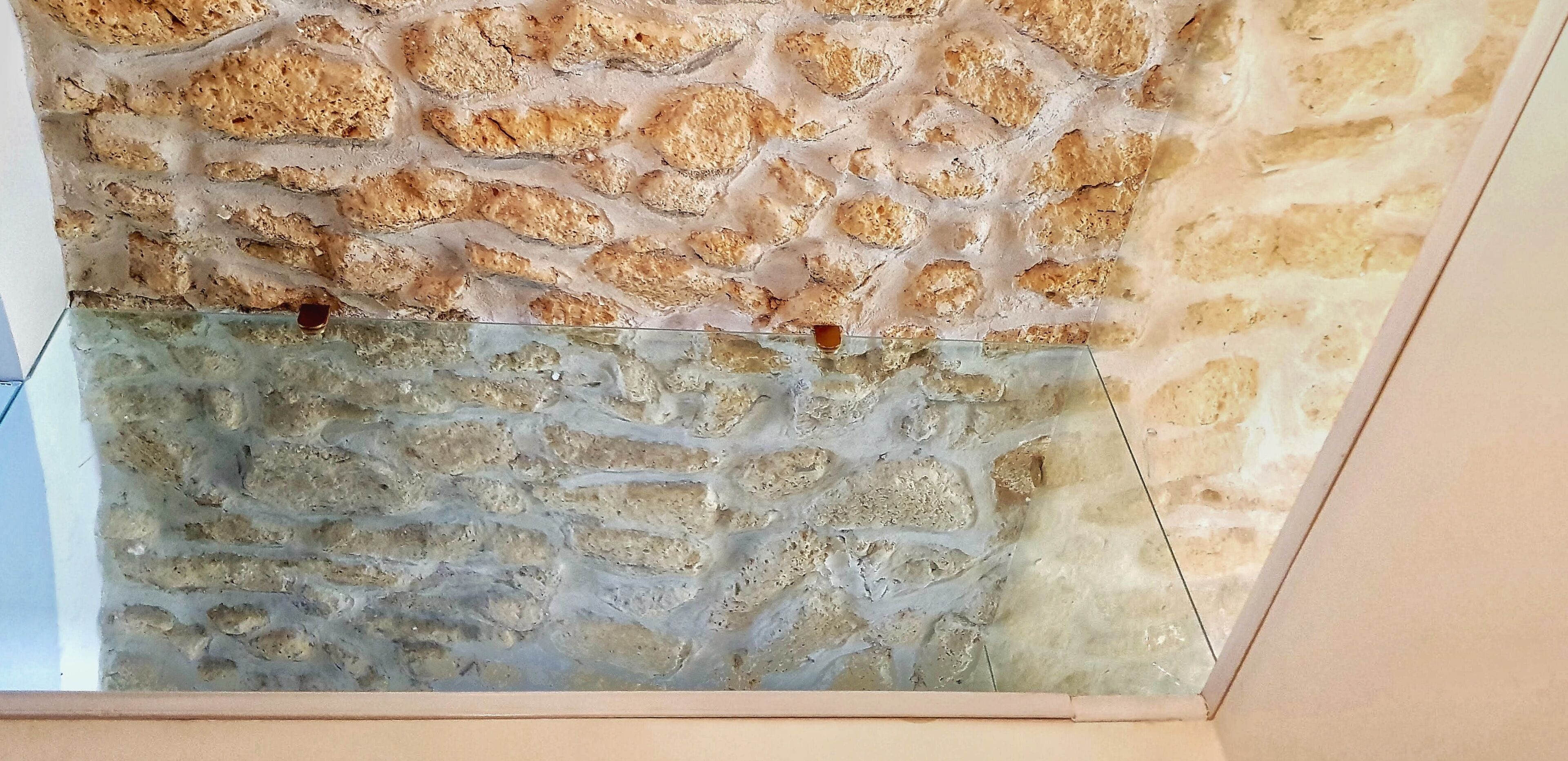 Un mur à texture, orné d’un motif rappelant la pierre, qui fait probablement partie du décor intérieur d’un bâtiment.