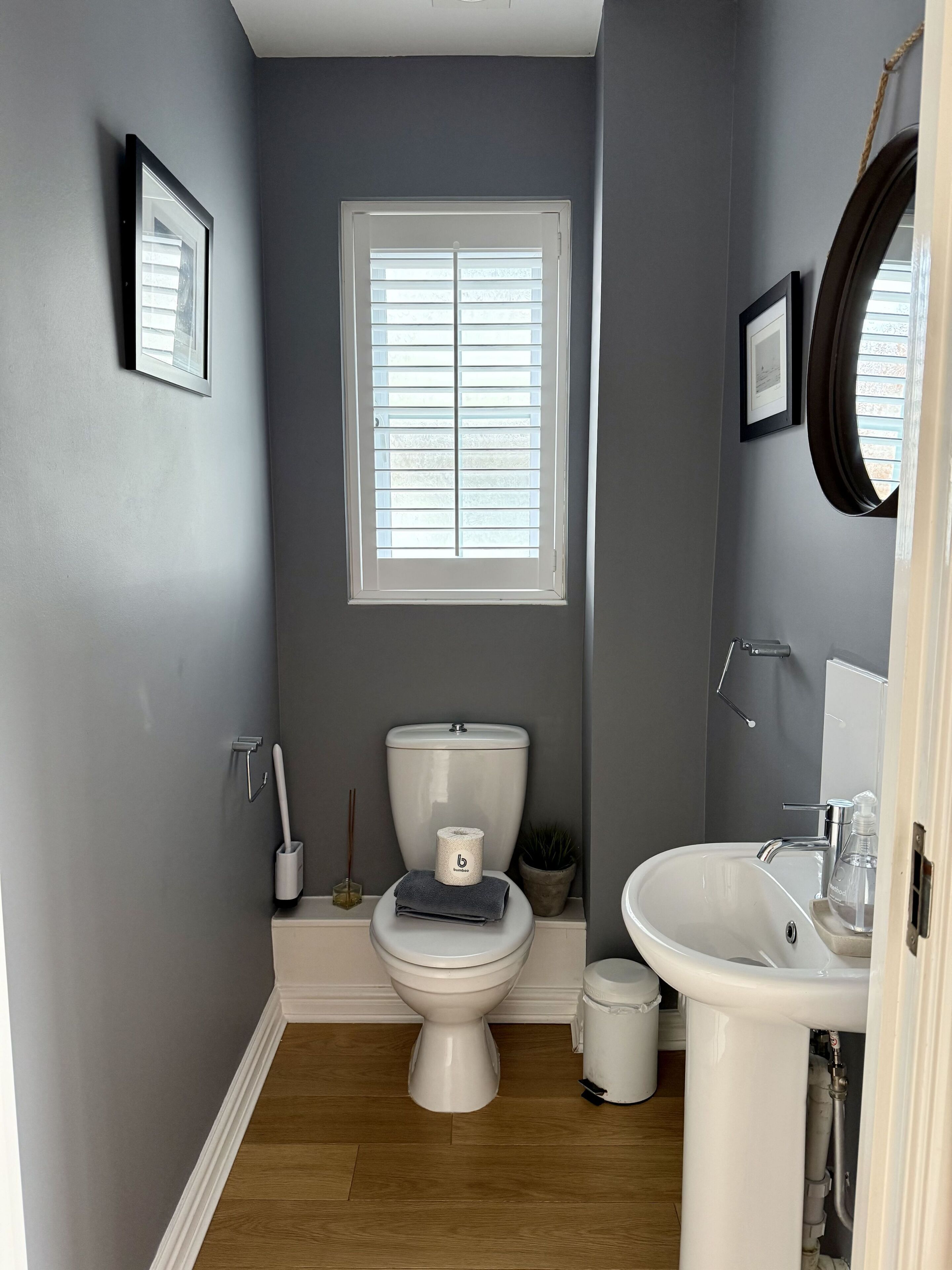 Een kleine badkamer met toilet, wastafel en raam.