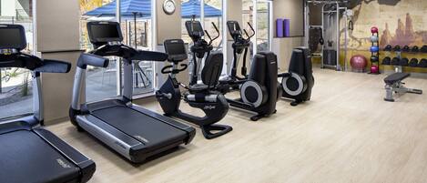 A gym with treadmills, elliptical machines, and weight equipment.