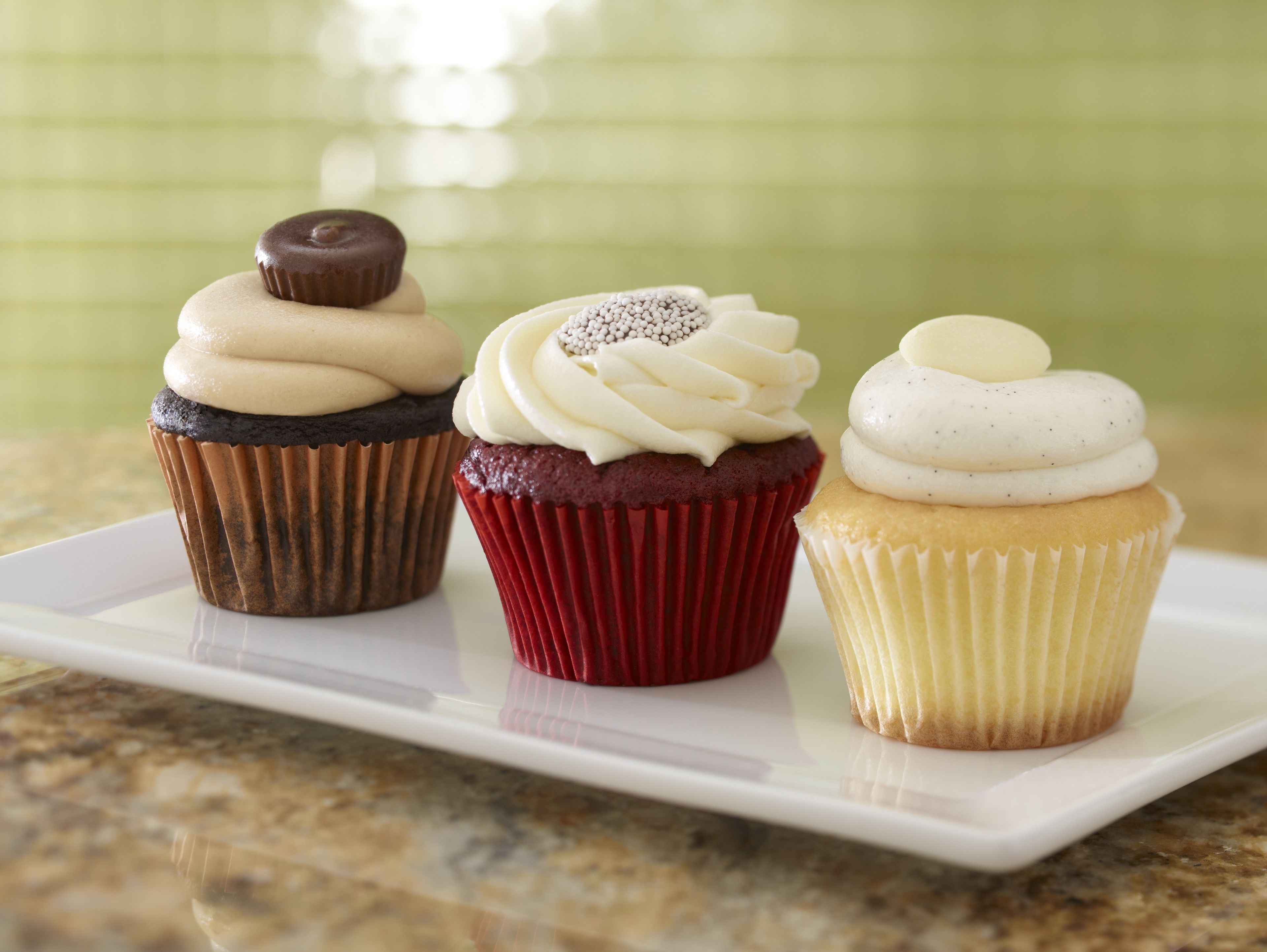 Three cupcakes on a white plate.