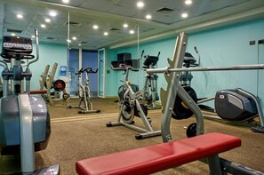 A gym with various exercise equipment, including treadmills, stationary bikes, and weight machines.