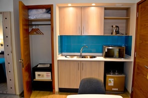A compact kitchenette with a sink, microwave, and a small refrigerator. - Diego de Almagro Talca Express (Talca)