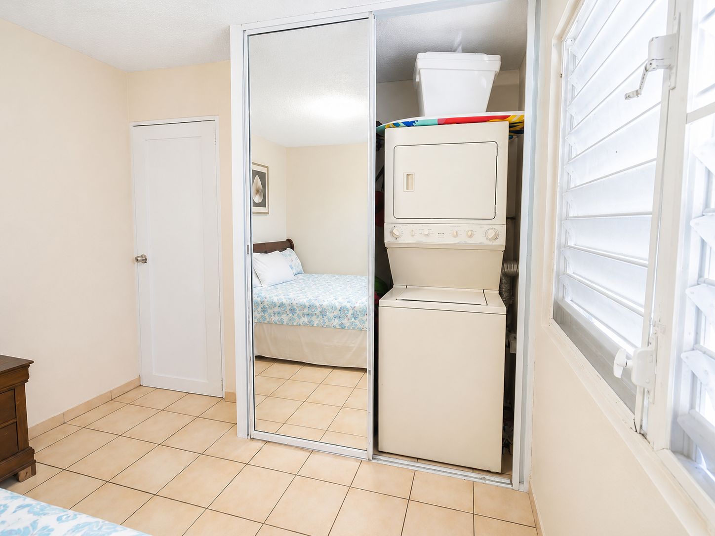 Une pièce comprenant un lit, une armoire et un lave-linge.