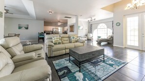 A spacious living room with a beige sofa, a wooden coffee table, and a patterned rug. - Exclusive Villa Fantastic Lakeview, Pool & Spa, Breathtaking Sunset (Cape Coral)