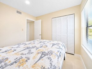 A bedroom with a bed, a closet, and a window with blinds. - Colinas del Atlantico Vacational House 1st Floor (Isabela)