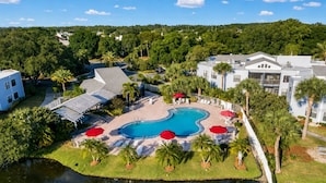 A resort with a swimming pool, palm trees, and a view of the surrounding area. - Colinas del Atlantico Vacational House 1st Floor (Isabela)