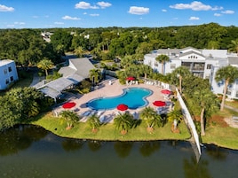 Un resort con piscina, palmeras y vistas del entorno.