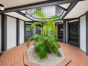 Interior moderno com planta central, claraboia e piso de tijolos.