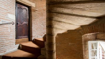 A staircase with a wooden door and a stone pillar.