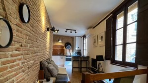 Een gezellige zithoek met een bakstenen muur, een bank, een bijzettafeltje en een raam met uitzicht.